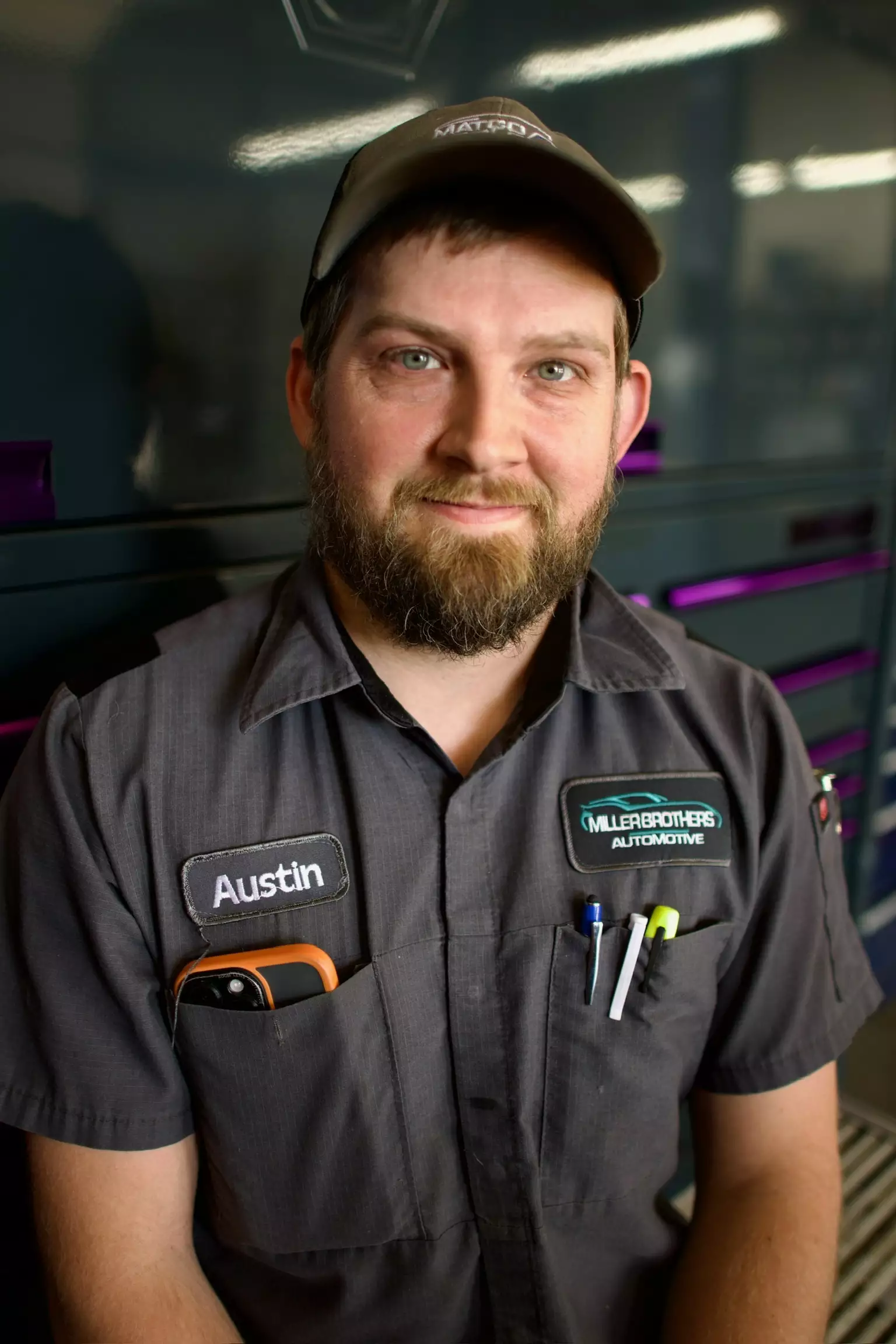 Austin, Automotive Technician at Miller Brothers Automotive, in uniform inside the garage, standing confidently near tool cabinets. Automotive Technician, Auto Repair In Tecumseh OK at Miller Brothers Automotive