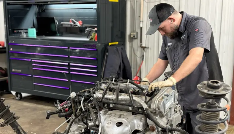 With a well-organized tool chest in the background, a mechanic at Miller Brothers Automotive conducts engine diagnostics & repair, a crucial service in their comprehensive auto repair offerings in Tecumseh, OK.