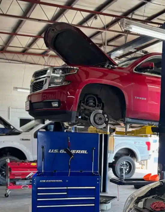 With its hood open and wheel removed, a red Chevrolet Tahoe is serviced at Miller Brothers Automotive, demonstrating their capability for fleet maintenance and all forms of auto repair in Tecumseh, OK. Fleet Maintenance in Tecumseh OK At Miller Brothers Automotive