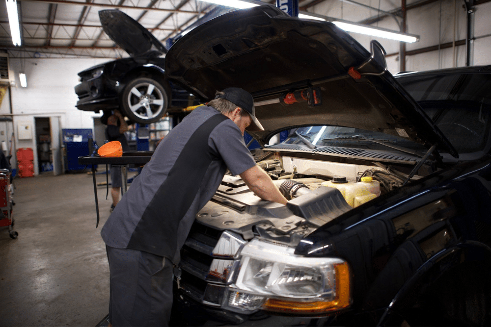 Auto Services in Tecumseh, OK. Miller Brothers Automotive. Image of a technician performing maintenance on a vehicle's engine, showcasing professional repair services in a fully equipped auto shop.