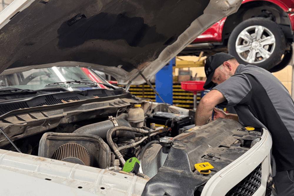 Engine repair in Tecumseh, OK by Miller Brothers Automotive. Image of a professional technician working under the hood of a truck, performing hands-on engine service and maintenance to restore performance, reliability, and safe daily driving.
