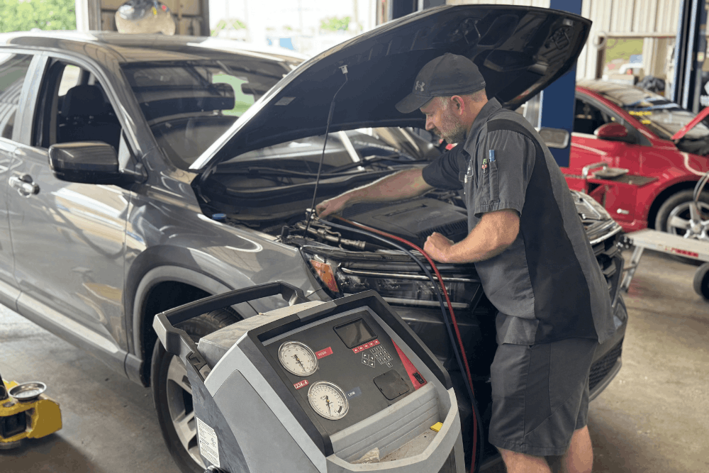 Auto a/c repair, auto repair in Tecumseh, OK by Miller Brothers Automotive. Image of a technician using specialized equipment to service a vehicle’s air conditioning system, ensuring optimal cooling performance, efficiency, and comfort during warmer driving conditions.